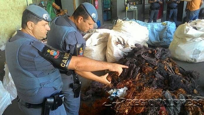 Policiais militares da Força Tática mostram cobre apreendido em depósito durante operação em Araçatuba (Foto: Charles Caleb/RegionalPress)