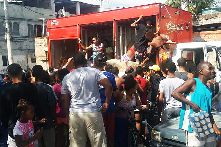 Moradores saqueiam caminhão de bebidas na Cidade de Deus, no Rio de Janeiro (Reprodução/Reprodução)