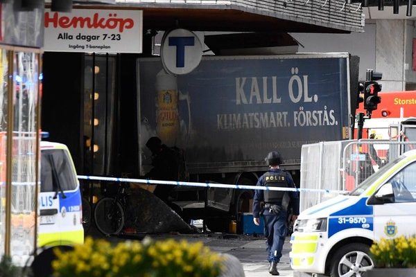 Policiais isolam área ao redor do caminhão que atropelou pessoas e invadiu uma loja de departamentos da rede Ahlens em Drottniggatan, bairro central de Estocolmo (Foto: Jonathan Nackstrand/AFP).