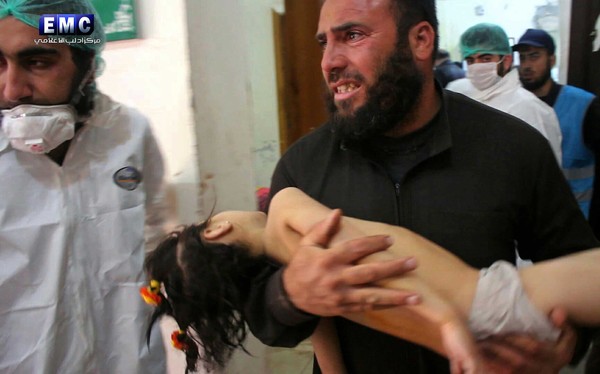 Homem socorre criança após suposto ataque químico em Idlib, no norte da Síria, nesta terça-feira (4) (Foto: Edlib Media Center, via AP).