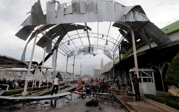 Bombeiros apagam incêndio em local de atentado a bomba em supermercado na cidade de Pattani, na Tailândia, na terça (9) (Foto: Reuters/Surapan Boonthanom).