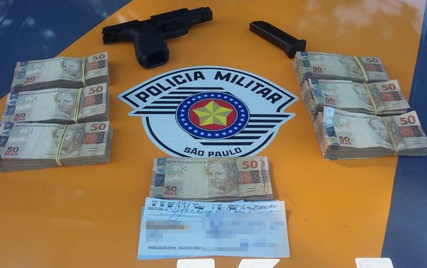 Dinheiro e arma apreendida pela polícia (Foto: Divulgação/Polícia Rodoviária)