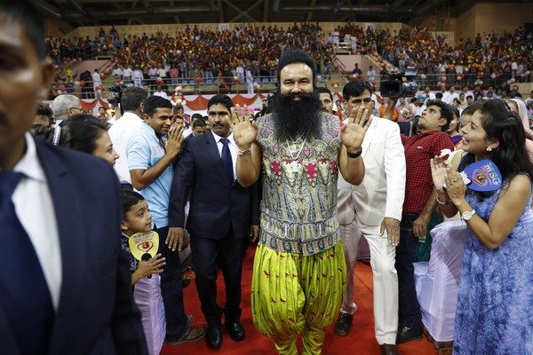 Em foto de 2015, Gurmeet Ram Rahim Singh (ao centro) cumprimenta seguidores durante lançamento de filme na Índia (Foto: AP Photo/Tsering Topgyal, File)