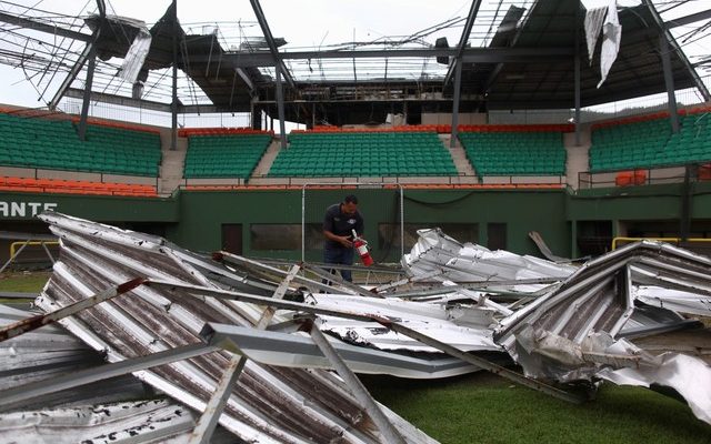 Um homem encontra um extintor de incêndio entre os escombros do estádio de beisebol Felix 'Nacho' Millan em Yabucoa, Porto Rico, depois que o furacão Maria atingiu a ilha em setembro de 2017 (Foto: Alvin Baez/Reuters).