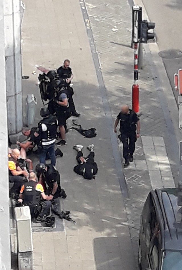 Forças especiais da polícia são vistas em Liège, na Bélgica, próximas de um homem no chão, supostamente o atirador (Foto: Isabelle Freres/RTL Belgium/Reuters).
