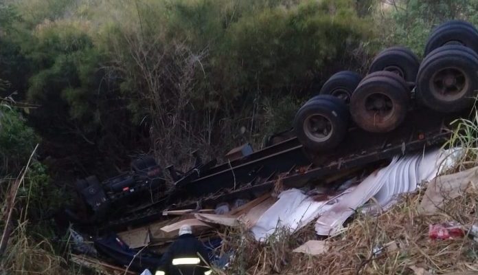 Carreta tombou com as rodas para cima, prensando o motorista na cabine. Foto: DIVULGAÇÃO