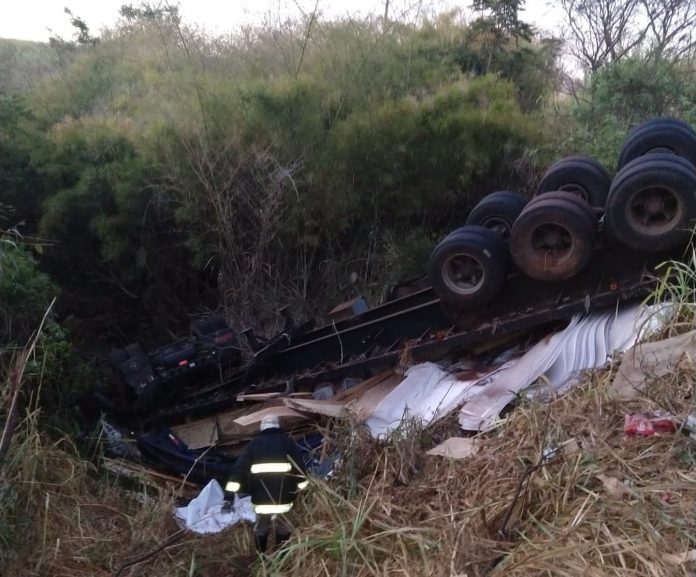 Carreta tombou com as rodas para cima, prensando o motorista na cabine. Foto: DIVULGAÇÃO