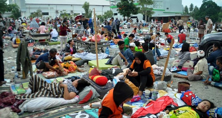 Feridos são atendidos nas ruas de Palu — Foto: Muhammad Rifki / AFP.