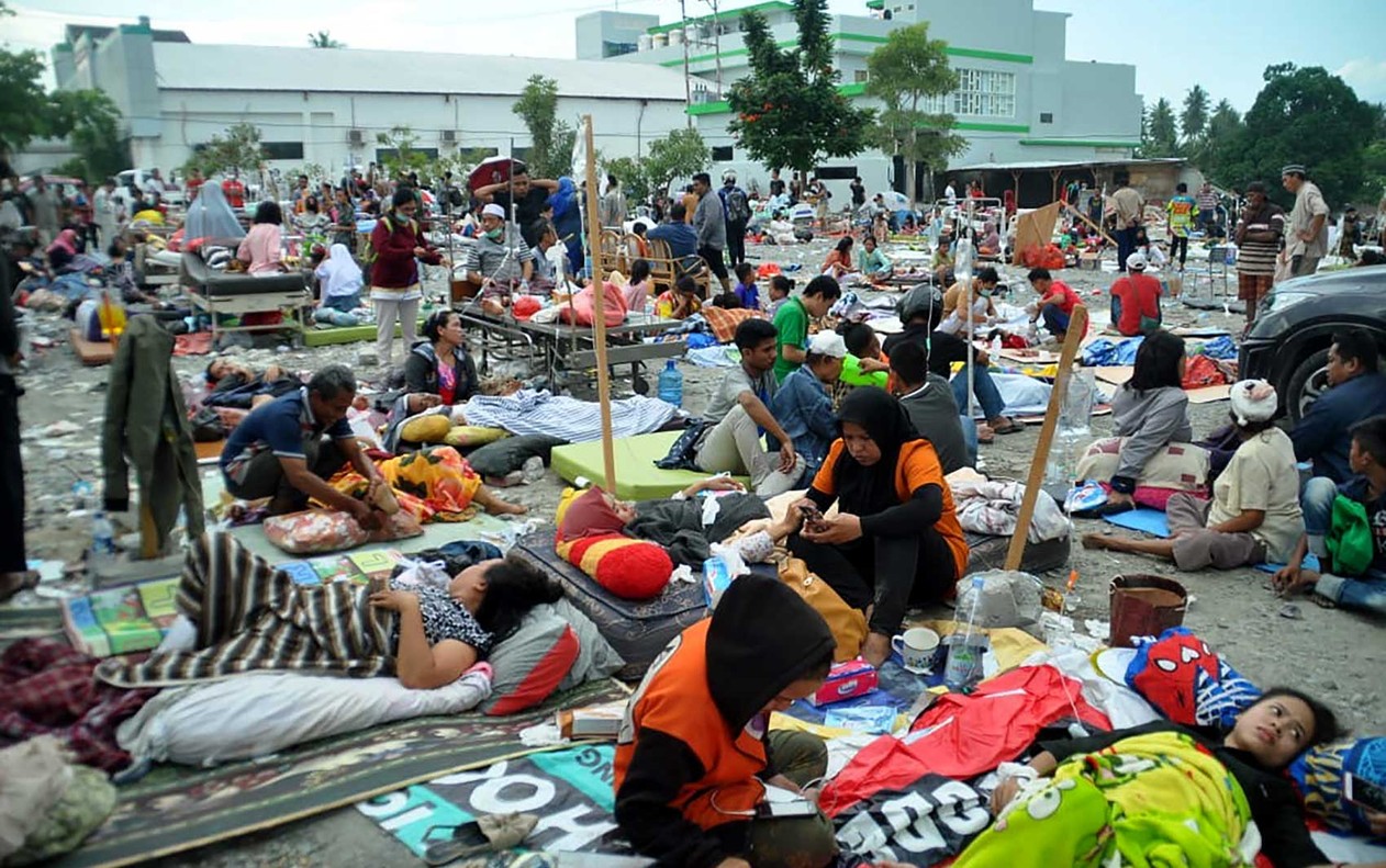 Feridos são atendidos nas ruas de Palu — Foto: Muhammad Rifki / AFP.