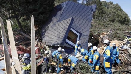 Equipes de resgate procuram sobreviventes de uma casa danificada cidade de Atsuma (Foto: Kyodo / via Reuters).