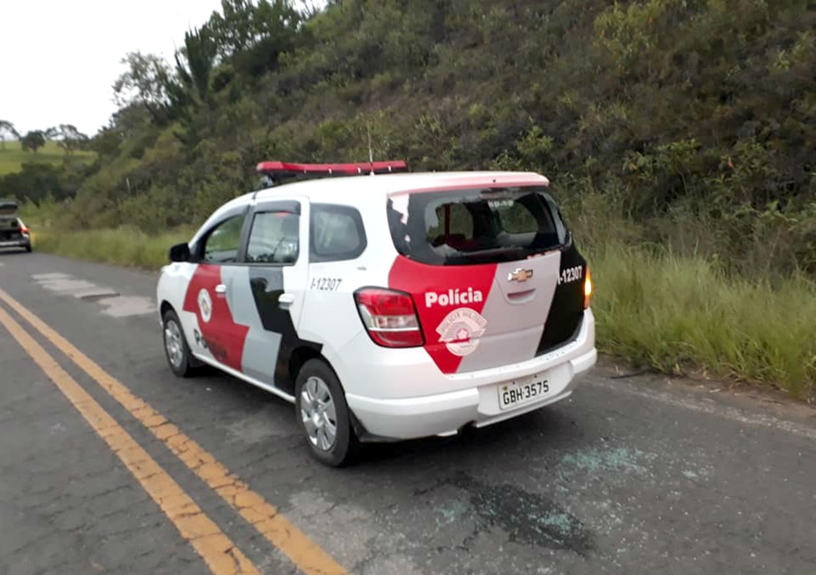 Viatura da PM teve o vidro traseiro estilhaçado por tiros durante a ação — Foto: JN Bofete/Divulgação.