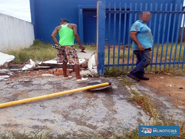 'Mario Gay', de camiseta verde limão, avalia estragos no muro de uma empresa para locação. Foto: MANOEL MESSIAS/Agência