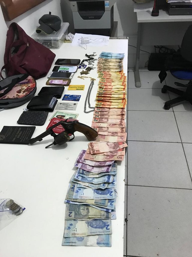 Com os suspeitos foram apreendidos um revólver, seis munições, R$ 1 mil em dinheiro, três celulares e uma bolsa feminina com diversos materiais, correntes e anéis. — Foto: PM-MT/Assessoria.