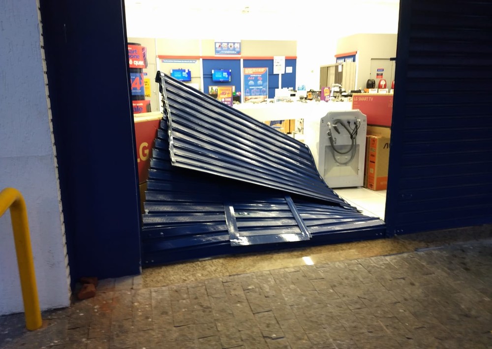 Porta da loja da rede Casas Bahia foi derrubada e ladrões furtaram aparelhos em Jaguariúna. — Foto: Roberto Torrecilhas.
