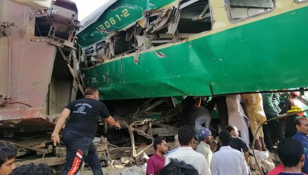 Socorristas paquistaneses e moradores se reúnem em volta dos destroços de trens que se chocaram no Paquistão na quinta-feira (11) — Foto: STR / AFP Photo.