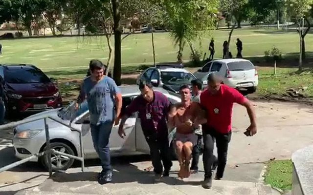 Márcio Júnior Silva de Souza, o Marcinho, tentou fugir e precisou ser algemado nas mãos e nos pés pelos policiais — Foto: Reprodução / TV Globo.