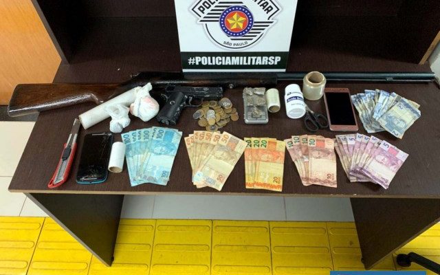 Foram apreendidos crack, maconha, espingarda sem munição, imitação de pistola, R$ 1.150,70 em dinheiro e petrechos para embalar a droga. Foto: DIVULGAÇÃO/PM