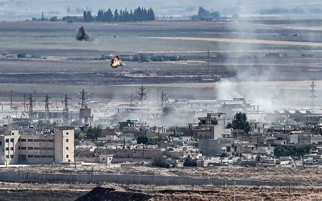 Fumaça é vista na cidade síria de Ras al-Ain, na fronteira com a Turquia, neste domingo (13) — Foto: Ozan Kose / AFP