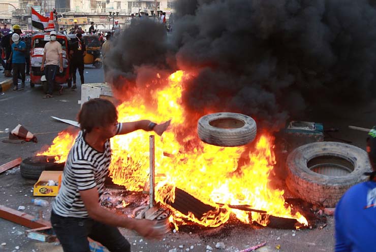 Manifestantes fazem barricada perto de emissora estatal do Iraque em Bagdá nesta segunda-feira (4) — Foto: Khalid Mohammed/AP Photo.