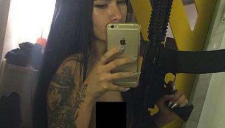 Investigada em Bebedouro, SP, a modelo Gabriela Sara Vasconcelos Assunção, de 19 anos, ostenta fuzil em foto — Foto: Reprodução.