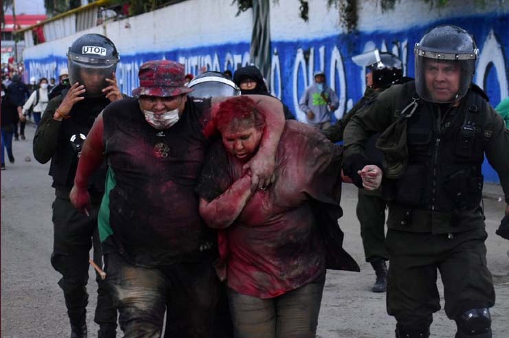 Patricia Arce, prefeita de Vinto, é resgatada por policiais; manifestantes incendiaram a prefeitura, jogaram tinta vermelha em Arce e cortaram seus cabelos — Foto: Daniel James/Los Tiempos Bolivia/via Reuters.