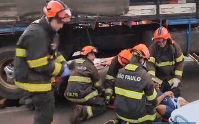 Mulher ficou literalmente enroscada embaixo das rodas do caminhão, mas felizmente não sofreu ferimentos graves. Foto: Reprodução/Impacto