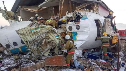 Aeronave partiu-se em duas partes ao colidir com um muro de concreto e uma casa — Foto: HO / Kazakhstan's emergencies committee / AFP.