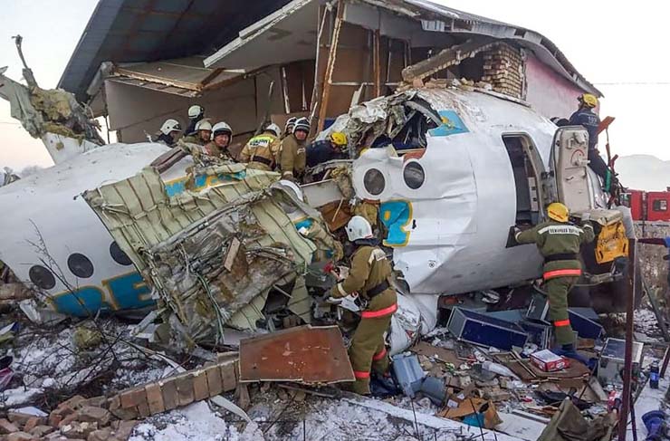 Aeronave partiu-se em duas partes ao colidir com um muro de concreto e uma casa — Foto: HO / Kazakhstan's emergencies committee / AFP.