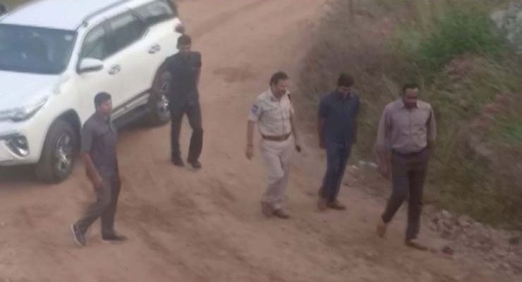 Frame mostra momento em que suspeitos, acompanhados da polícia, chegam nesta sexta-feira (6) para reconstituição de estupro e morte de veterinária em Hyderabad, na Índia — Foto: ANI/via Reuters TV.