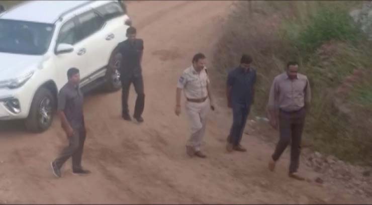 Frame mostra momento em que suspeitos, acompanhados da polícia, chegam nesta sexta-feira (6) para reconstituição de estupro e morte de veterinária em Hyderabad, na Índia — Foto: ANI/via Reuters TV.