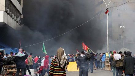 Manifestantes são vistos entre a fumaça subindo de tendas em chamas enquanto forças de segurança iraquianas atacam na Praça Tahrir durante protestos contra o governo em Bagdá — Foto: Thaier al-Sudani/Reuters.