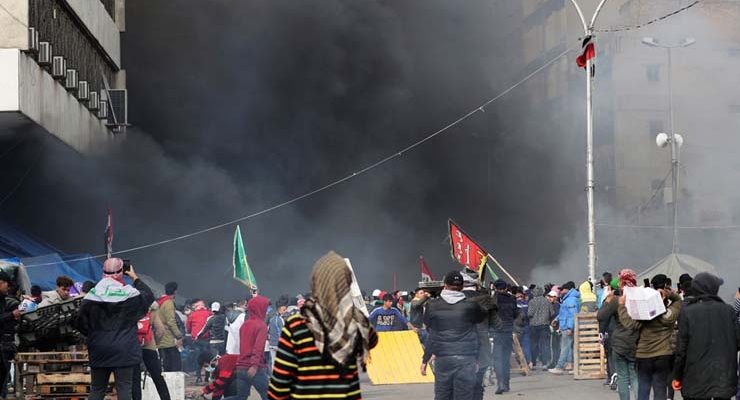 Manifestantes são vistos entre a fumaça subindo de tendas em chamas enquanto forças de segurança iraquianas atacam na Praça Tahrir durante protestos contra o governo em Bagdá — Foto: Thaier al-Sudani/Reuters.