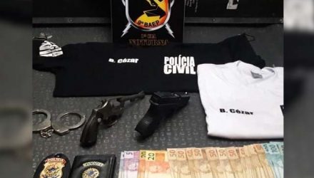 Com o suspeito foram encontradas duas armas, um revólver calibre 32, com quatro munições, um simulacro de pistola, um par de algemas, carteira e distintivo da Polícia Civil, duas camisetas com escritas da Polícia Civil e R$ 1,6 mil. Foto: Divulgação/DLnews