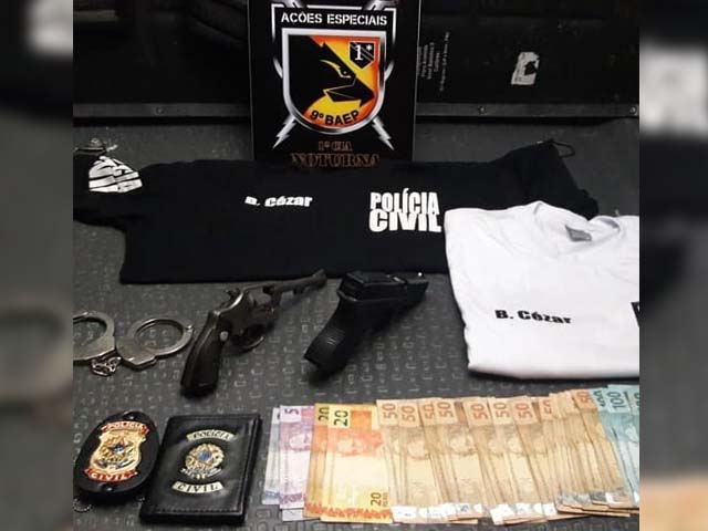 Com o suspeito foram encontradas duas armas, um revólver calibre 32, com quatro munições, um simulacro de pistola, um par de algemas, carteira e distintivo da Polícia Civil, duas camisetas com escritas da Polícia Civil e R$ 1,6 mil. Foto: Divulgação/DLnews