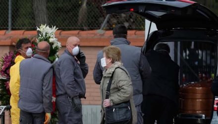 Agentes funerários carregam o caixão com vítima de Covid-19, no cemitério em Leganes, na Espanha, na terça-feira (24) — Foto: Manu Fernandez / AP.