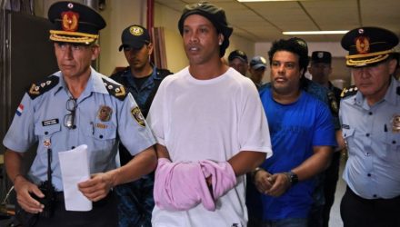 Ronaldinho e o irmão chegam algemados para audiência. Foto: NORBERTO DUARTE/AFP via Getty Images