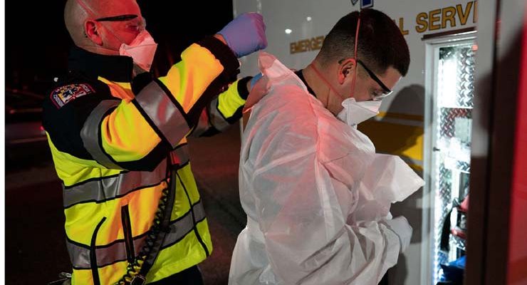 Paramédicos do departamento de bombeiros do condado de Anne Arundel County vestem equipamento de proteção para atender chamado relacionado a um possível paciente com Covid-19, em Glen Burnie, Maryland — Foto: Alex Edelman/AFP.