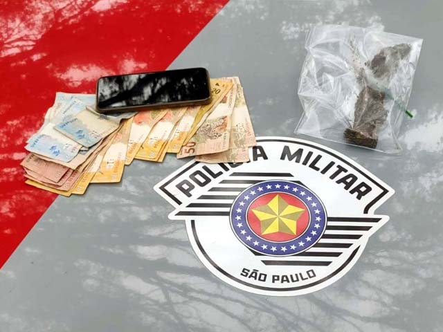Foram apreendidos os 4 pequenos tabletes de maconha, R$ 453,00 em dinheiro e um telefone celular. Foto: DIVULGAÇÃO/PM