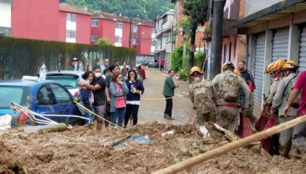 Moradores do Morro da Oficina observam a retirada de mais um corpo dos escombros da região, em Petrópolis — Foto: Reprodução/ TV Globo