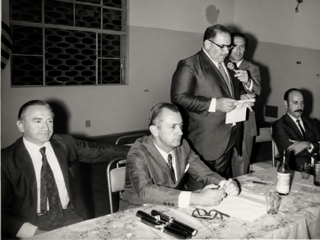 Professor José Antônio Mariani, paraninfo de turma, discursa durante solenidade de entrega de certificados da Escola Técnica Rui Barbosa, em Andradina, na década de 1970. Também participaram da cerimônia João Esteves, Walter Ramalho, diretor da instituição, Décio Gava e o delegado Edson Monteiro de Barros.